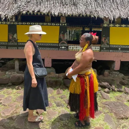 Palau Explorer tour guide in local attire with guest in front of a Bai (men's house)