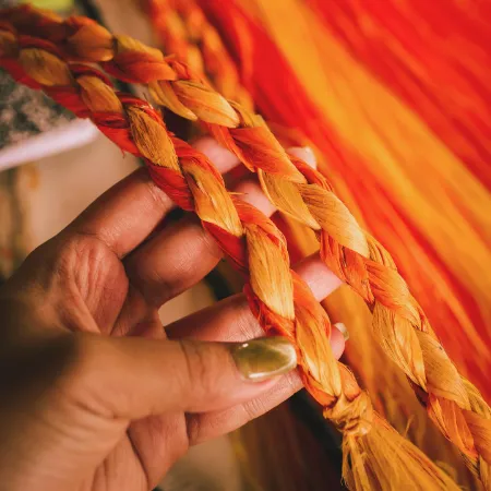 hand inspecting a colorful grass skirt