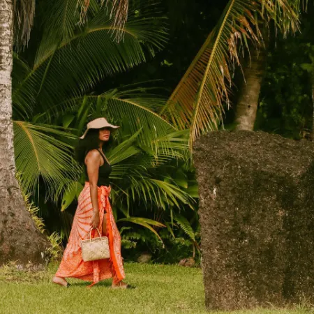 woman with bag and hat walking towards a sacred rock in Palau