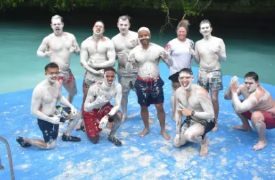 group of men full of white mud at Milky Way Lagoon in Palaut